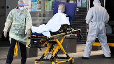 Nhân viên y tế chuyển bệnh nhân nhiễm COVID-19 tới bệnh viện ở Melbourne, Australia. Ảnh: AFP/TTXVN