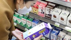 Một người tiêu dùng Hàn Quốc đang đọc hạn sử dụng in trên vỏ hộp sữa (Ảnh: The Korea Times)