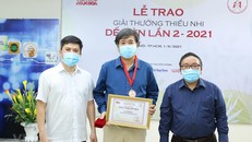Ông Lê Xuân Thành, Trưởng Ban tổ chức Giải (trái) và nhà thơ Trần Đăng Khoa, Chủ tịch Hội đồng giám khảo (phải) trao giải cho tác giả Bình Ca (giữa). (Ảnh: Hòa Nguyễn/Vietnam+)