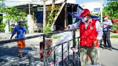 Nhân viên Hội Chữ thập Đỏ thành phố Đà Nẵng đặt "túi hàng gia đình" ở điểm quy định để người dân trong khu phong tỏa đến nhận, đảm bảo công tác phòng, chống dịch. Ảnh minh họa: TTXVN phát