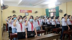 Các học sinh trường THCS Trần Phú (Phủ Lý) thực hiện nghi lễ chào cờ trong buổi khai giảng ngay tại lớp thông qua hệ thống trực tuyến của trường, ngày 5/9/2021.