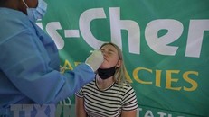 Nhân viên y tế lấy mẫu xét nghiệm COVID-19 cho hành khách tại sân bay quốc tế OR Tambo ở Johannesburg, Nam Phi, ngày 27/11/2021. (Ảnh: AFP/TTXVN)