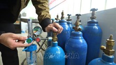 Thành viên Tổ hỗ trợ theo dõi người mắc COVID-19 tại nhà ở phường Lĩnh Nam (quận Hoàng Mai, Hà Nội) kiểm tra bình oxy trước khi mang đến hỗ trợ F0 cách ly y tế, điều trị tại nhà. Ảnh: Minh Quyết/TTXVN