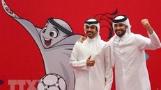Người dân chụp ảnh bên hình ảnh linh vật World Cup Qatar 2022 ở Doha. (Ảnh: AFP/TTXVN)