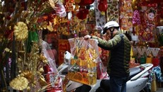 Người dân mua những vật phẩm truyền thống đồ cúng để cúng tiễn ông Công ông Táo về chầu trời. (Nguồn: TTXVN)