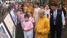 Đại biểu cùng các em nhỏ tham quan triển lãm. 