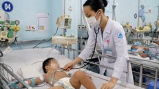 Bác sỹ Bệnh viện Nhi đồng 1 Thành phố Hồ Chí Minh thăm khám cho trẻ mắc bệnh tay chân miệng. (Ảnh: TTXVN phát)