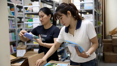 Các giáo viên chuẩn bị sách vở cho học sinh năm học mới với sự sáp nhập trường. 
