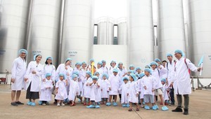 Các bé chụp ảnh cùng bố mẹ tại khu vực bồn chứa sữa tươi khổng lồ của nhà máy.
