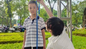 Nhân viên y tế đo chiều cao cho trẻ tại ngày hội.