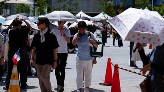 Người đi đường sử dụng ô che nắng tại Osaka, Nhật Bản.