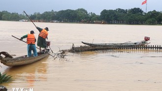 Công nhân dọn rác do lũ cuốn dạt vào bờ Nam sông Hương, thành phố Huế sáng 2/11. Ảnh: Nguyên Lý /TTXVN.