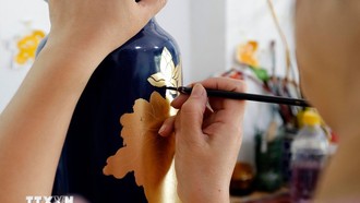 Vẽ hoa văn trên sản phẩm gốm sứ tại làng nghề Hạ Thái. Ảnh: Trần Việt/TTXVN.