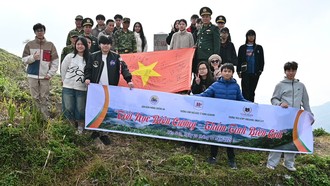 Đại diện học sinh hai tập thể lớp chụp ảnh lưu niệm tại mốc biên giới Việt - Lào. Ảnh: Nguyệt Linh