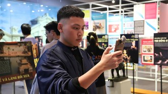 Khách tham quan trải nghiệm các tích trò rối nước bằng công nghệ AR tại triển lãm