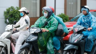 Nhiều người phải mặc áo mưa giữ ấm.