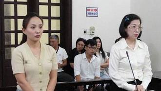 Hai bị cáo Hoàng Kim Ngân (áo dài trắng) và Phạm Thị Lan Hương tại phiên tòa. 