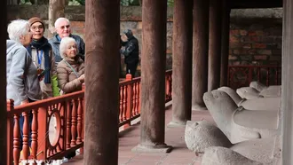 Du khách quốc tế tham quan khu nhà bia lưu danh các tiến sỹ tại Văn Miếu-Quốc Tử Giám. Ảnh: Hoàng Hiếu/TTXVN.