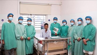 Ekip y bác sĩ Bệnh viện Trung ương Huế thực hiện ca phẫu thuật và bệnh nhân. Ảnh: TTXVN