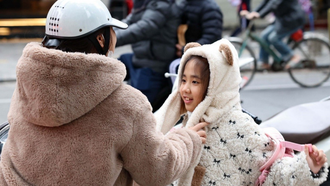 Trẻ em được giữ ấm khi lưu thông bằng xe máy trong những ngày rét đậm