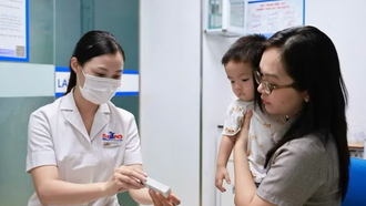 Phụ huynh đưa trẻ đi tiêm vaccine.