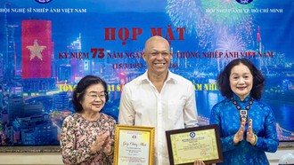 Nguyên Phó Chủ tịch nước Trương Mỹ Hoa (bìa trái) chúc mừng NSNA Nguyễn Á nhận tước hiệu Nghệ sĩ Nhiếp ảnh đặc biệt xuất sắc (E.VAPA/G)