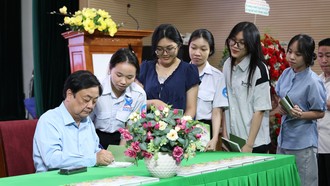 Tác giả Lê Minh Hoan (bút danh Xích Lô) ký tặng lên sách “Mỗi nghề một bông hoa” cho bạn đọc. Ảnh: Trung Nghĩa