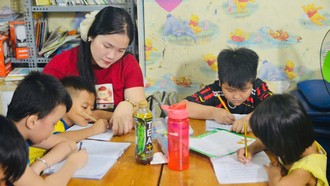 Chị Danh Thị Thanh Thúy (áo đỏ) đang dạy các em nhỏ học chữ.