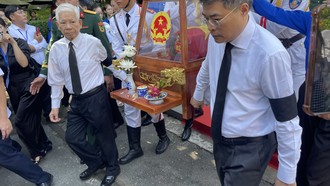 Thủ tướng Lê Minh Hưng và nguyên Chủ tịch nước Nguyễn Minh Triết cùng di quan hài cốt liệt sĩ ra xe về nơi an nghỉ cuối cùng. Ảnh: Hoàng Nhân
