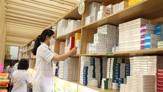 Nhân viên y tế cấp phát thuốc bảo hiểm y tế cho người bệnh.