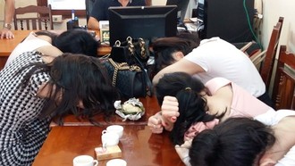 Các gái bán dâm bị bắt quả tang, đưa về cơ quan điều tra trong vụ đường dây mại dâm 14.000 USD.
