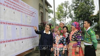 Tổ trưởng Tổ bầu cử số 5 của xã Quy Mông (Lào Cai) giới thiệu các đại biểu ứng cử để người dân hiểu và nắm được. Ảnh: Đinh Thùy/TTXVN