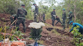 Các chiến sĩ cất bốc, quy tập hài cốt của 3 liệt sĩ trong cùng một ngôi mộ.
