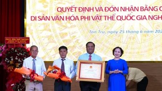 Bà Trần Thị Đoan Quang, Giám đốc Bảo tàng tỉnh Tây Ninh trao Bằng chứng nhận Di sản Văn hóa Phi vật thể Quốc gia đối với Nghề làm trống Bình An cho lãnh đạo Ủy ban Nhân dân xã Tân Trụ. (Ảnh: Thanh Bình/TTXVN)