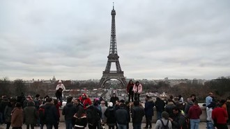 Khách du lịch chụp ảnh bên Tháp Eiffel ở thủ đô Paris, Pháp. (Ảnh: AFP/TTXVN)