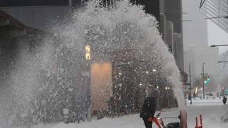 Người dân dọn tuyết trên đường phố tại New York, Mỹ.