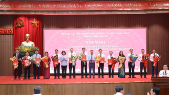 Chủ tịch Hội đồng Nhân dân thành phố Hà Nội Phùng Thị Hồng Hà và Phó Bí thư Thành ủy Hà Nội Nguyễn Văn Phong trao các quyết định của Ban Thường vụ Thành ủy Hà Nội cho các đồng chí.