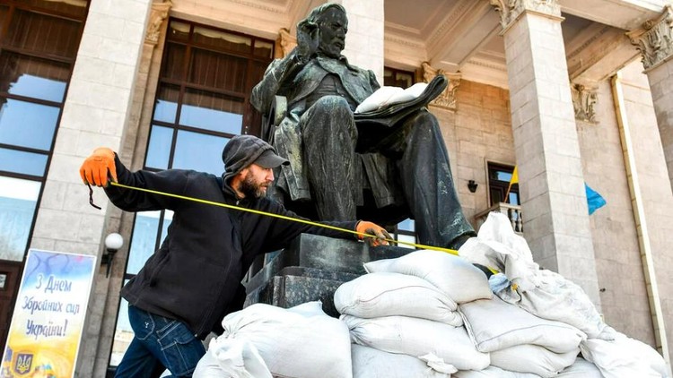 Một người đàn ông làm công việc bảo vệ bức tượng của nhà soạn nhạc người Nga Mikhail Glinka bên ngoài Phòng hòa nhạc Mikhail Glinka ở Zaporizhzhia, Ukraine. 