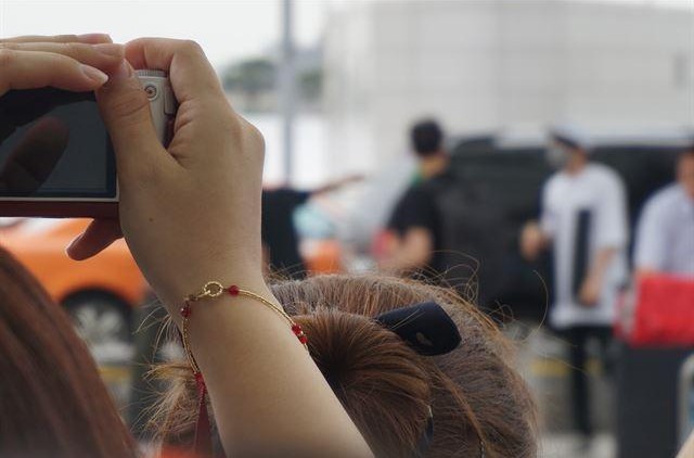 Người hâm mộ chụp ảnh một nhóm nhạc K-pop lên đường biểu diễn ở nước ngoài tại Sân bay Quốc tế Incheon. Ảnh: Korea Times