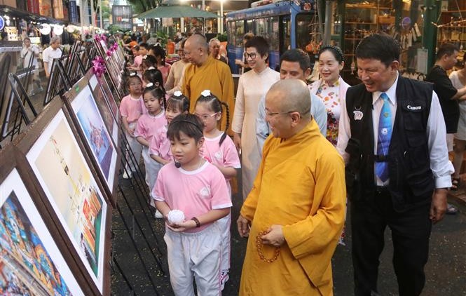 Đại biểu cùng các em nhỏ tham quan triển lãm. 