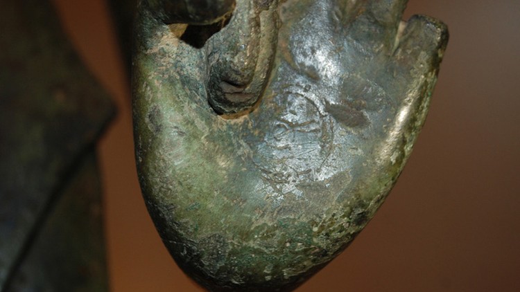 Hình chuyển pháp luân được khắc chìm trong lòng bàn tay trái của tượng.