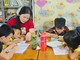 Chị Danh Thị Thanh Thúy (áo đỏ) đang dạy các em nhỏ học chữ.