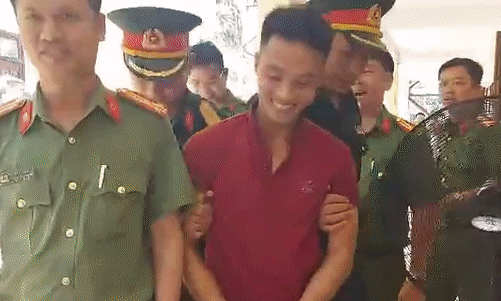 Triệu Quân Sự cười rất tươi khi bị còng tay, dẫn giải