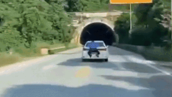 Ô tô phóng nhanh chạy trốn mặc cảnh sát đu phía sau xe