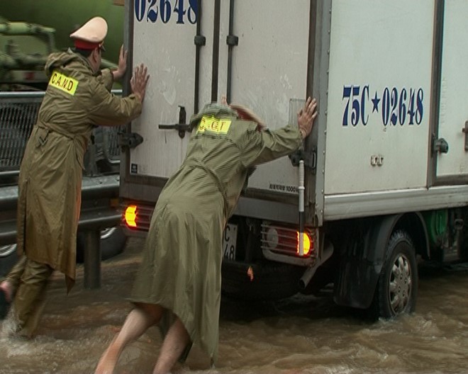 Cảnh sát giao thông bế trẻ qua đoạn nước lụt ảnh 1