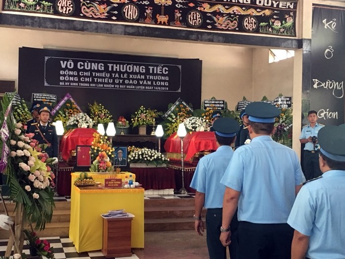 Nghẹn ngào hình ảnh vợ ôm con thơ ngơ ngác trong lễ tang phi công hy sinh ảnh 1