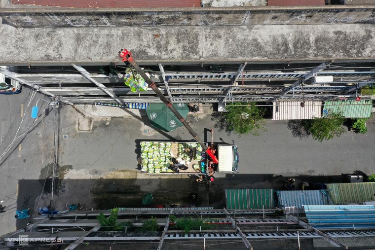 Dùng cần cẩu phát nhu yếu phẩm cho cư dân ảnh 9