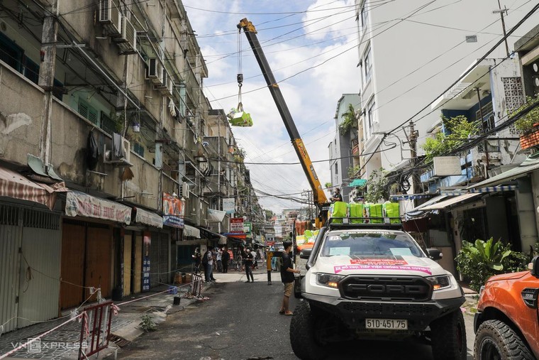 Dùng cần cẩu phát nhu yếu phẩm cho cư dân ảnh 1