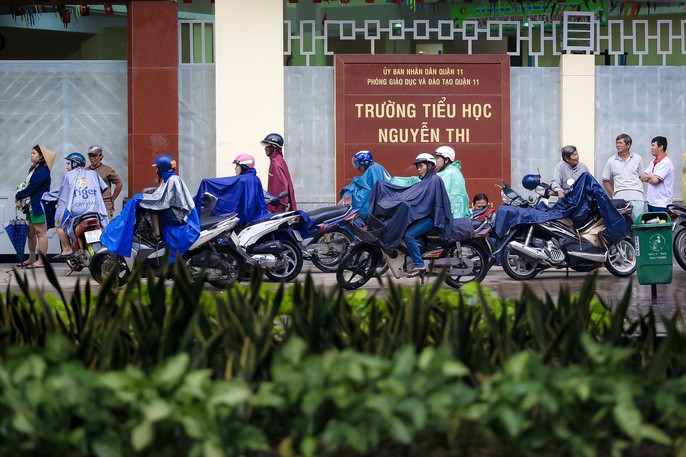 TP HCM: Phụ huynh đội mưa đón con tránh bão số 16 (Tembin) ảnh 5