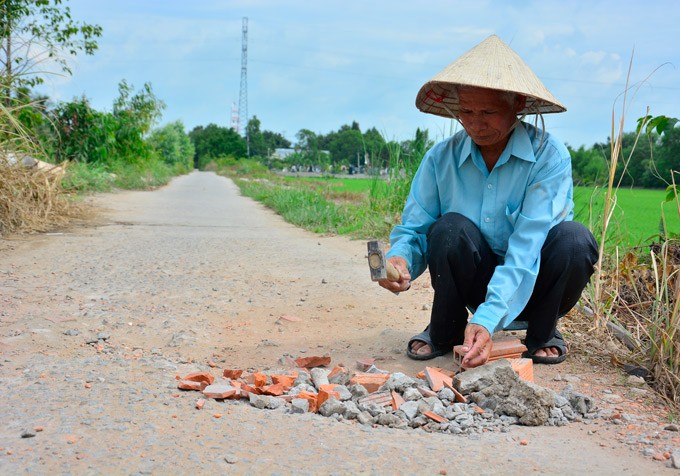 Bất kể nắng mưa, U80 hơn chục năm lặng lẽ vá đường ảnh 1